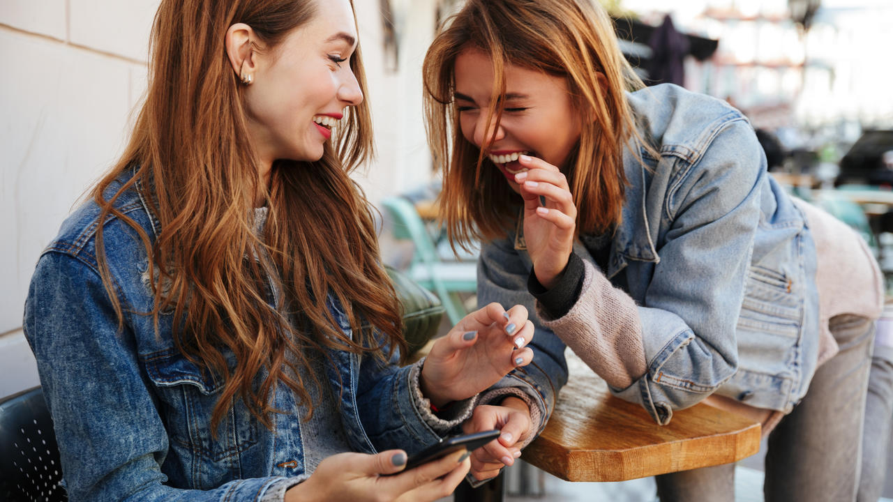 Two young women share a laugh together.