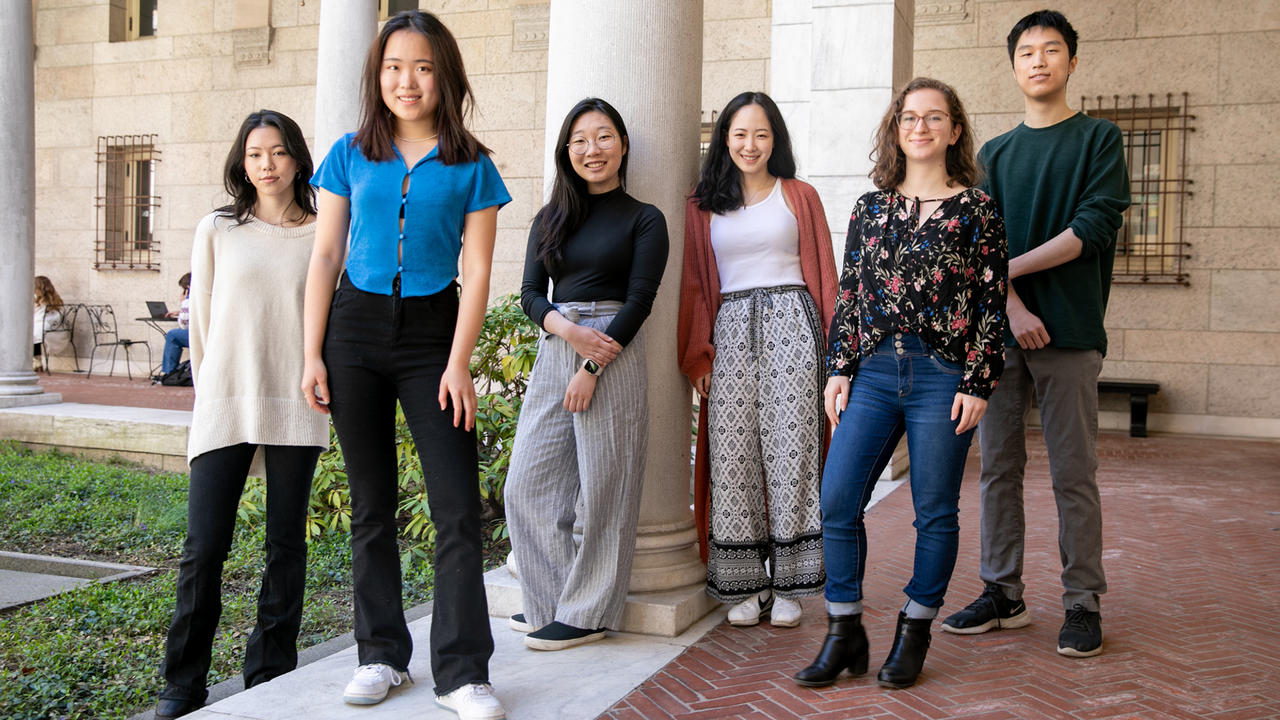 Five women and one man stand together for a group photo.