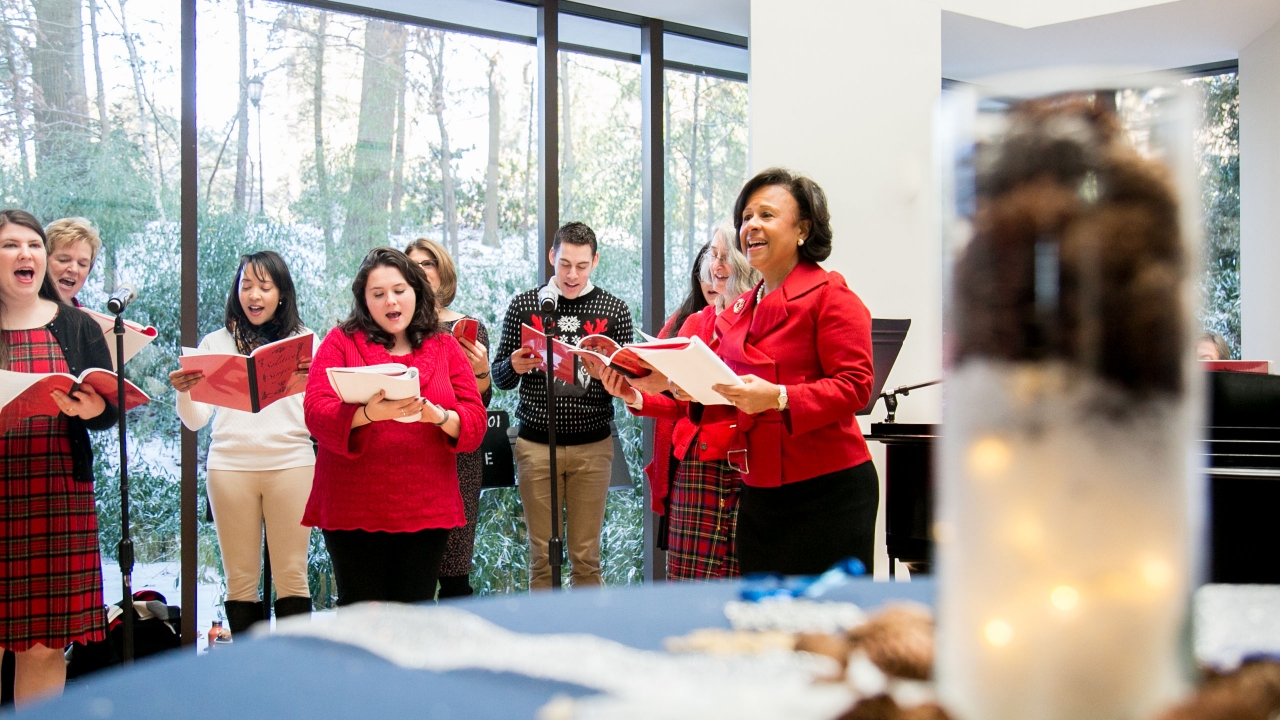 A staff choir sings with President Johnson